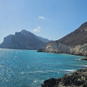 Cliffside view of azure sea and rugged rock formations by Mughsail.